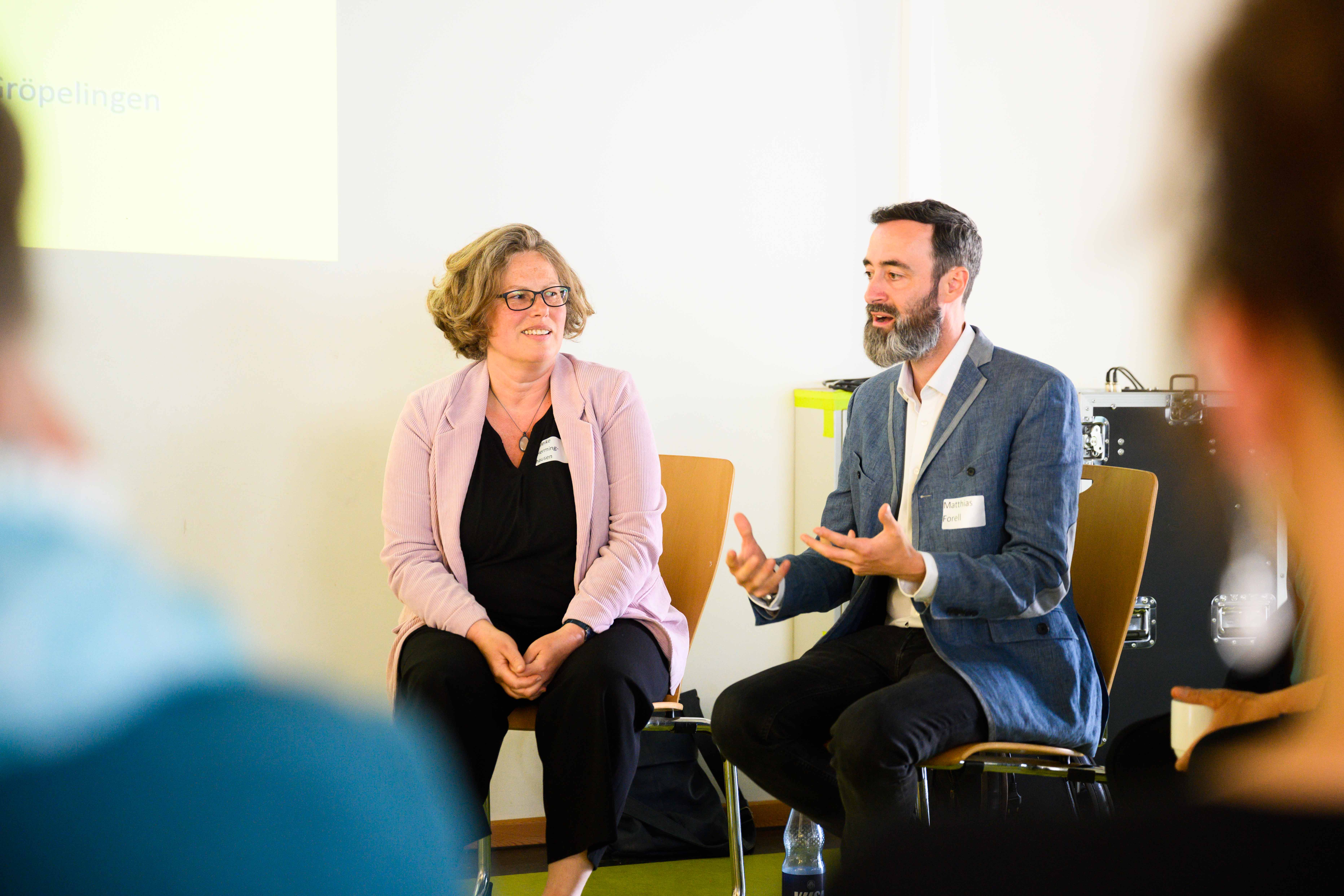 Prof. Matthias Forell und Meike Herminghausen sitzen im Kreis mit Workshopteilnehmenden
